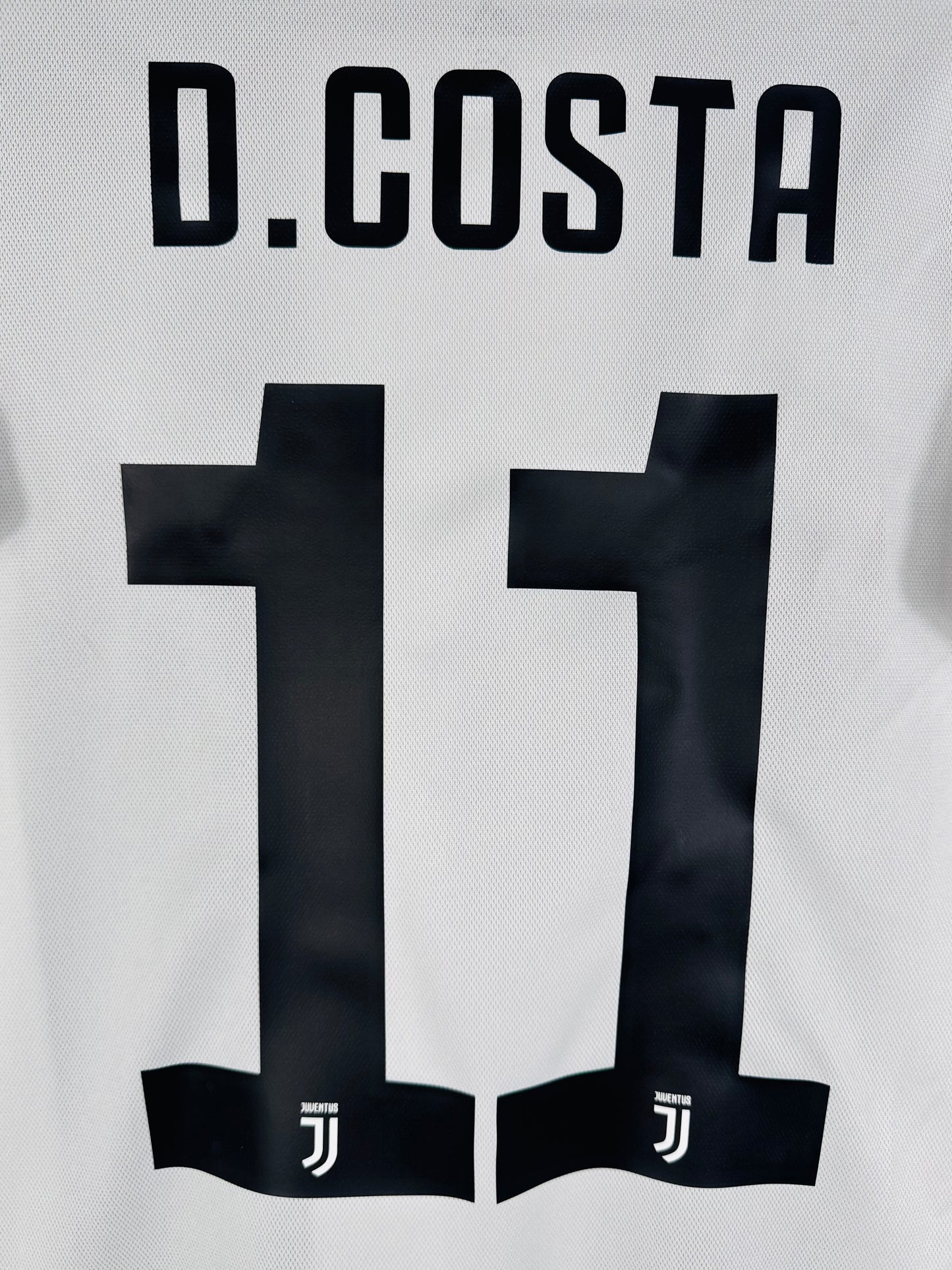 Zoom sur le nom D.COSTA et le numéro 11 avec motif officiel dans le chiffre.