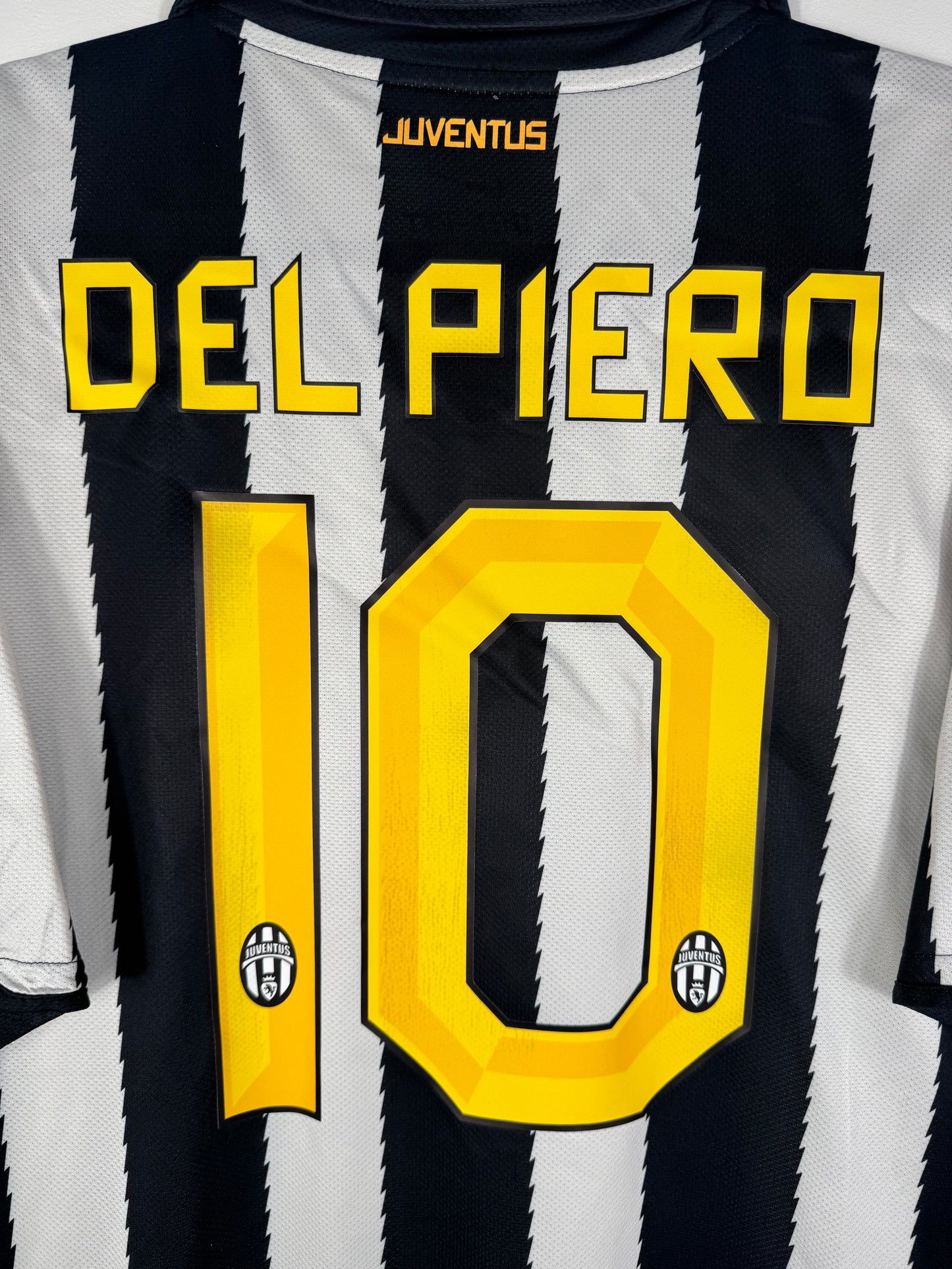Zoom sur le nom DEL PIERO et le numéro 10 noir avec bordure jaune, police officielle Juve 2011.
