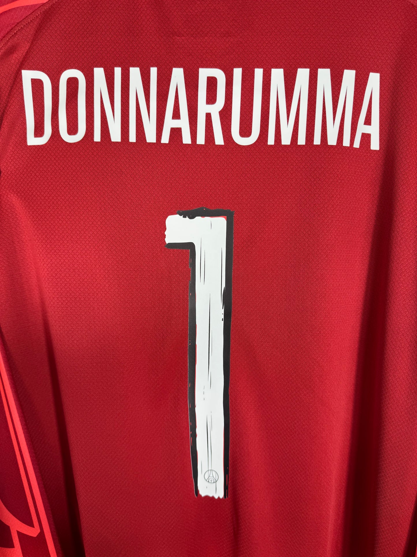 Zoom sur le nom DONNARUMMA et le numéro 1, police officielle du Paris Saint-Germain 2025.