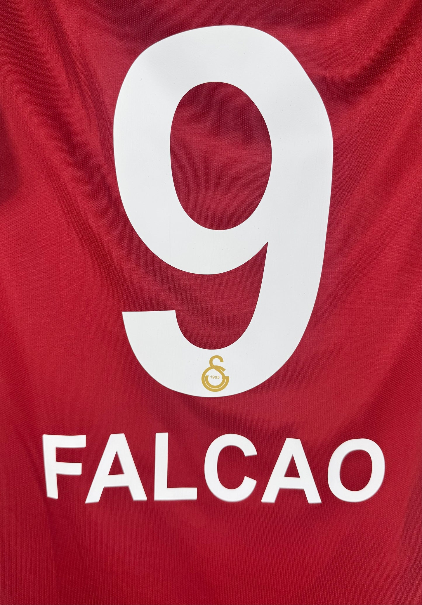 Zoom sur le nom FALCAO et le numéro 9 blanc avec détail du club en bas.