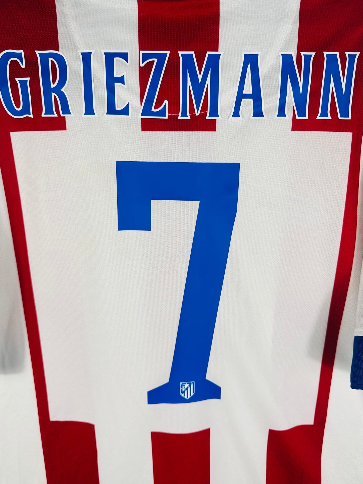Zoom sur le nom GRIEZMANN et le numéro 7 bleu au style carré officiel.