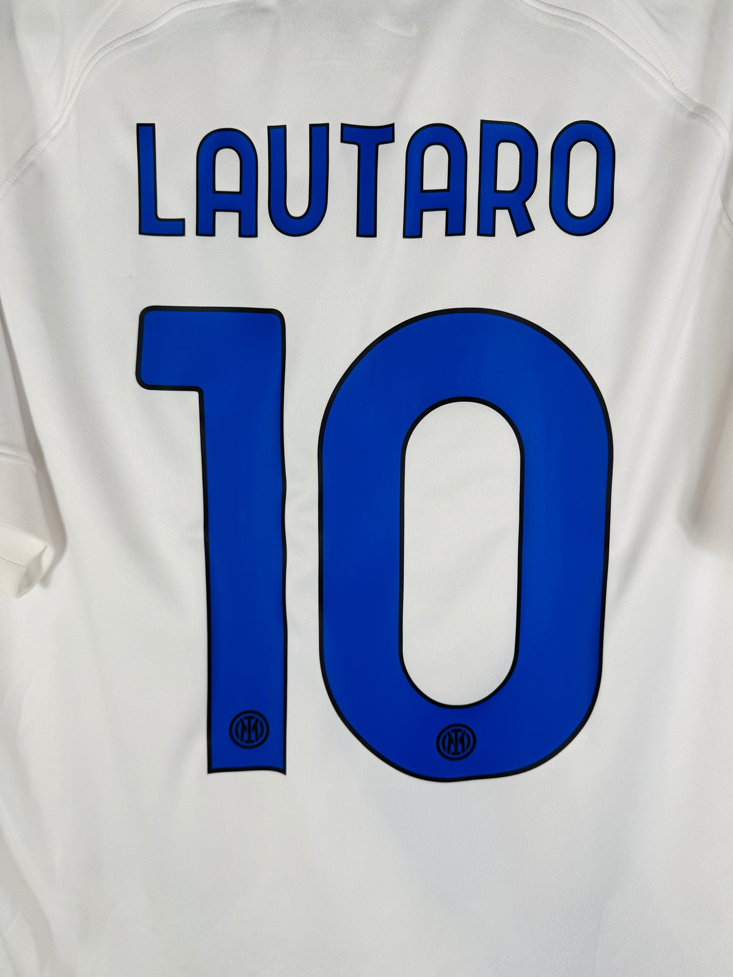 Zoom sur le nom LAUTARO et le numéro 10 bleu avec le blason de l'Inter intégré dans la base du chiffre.