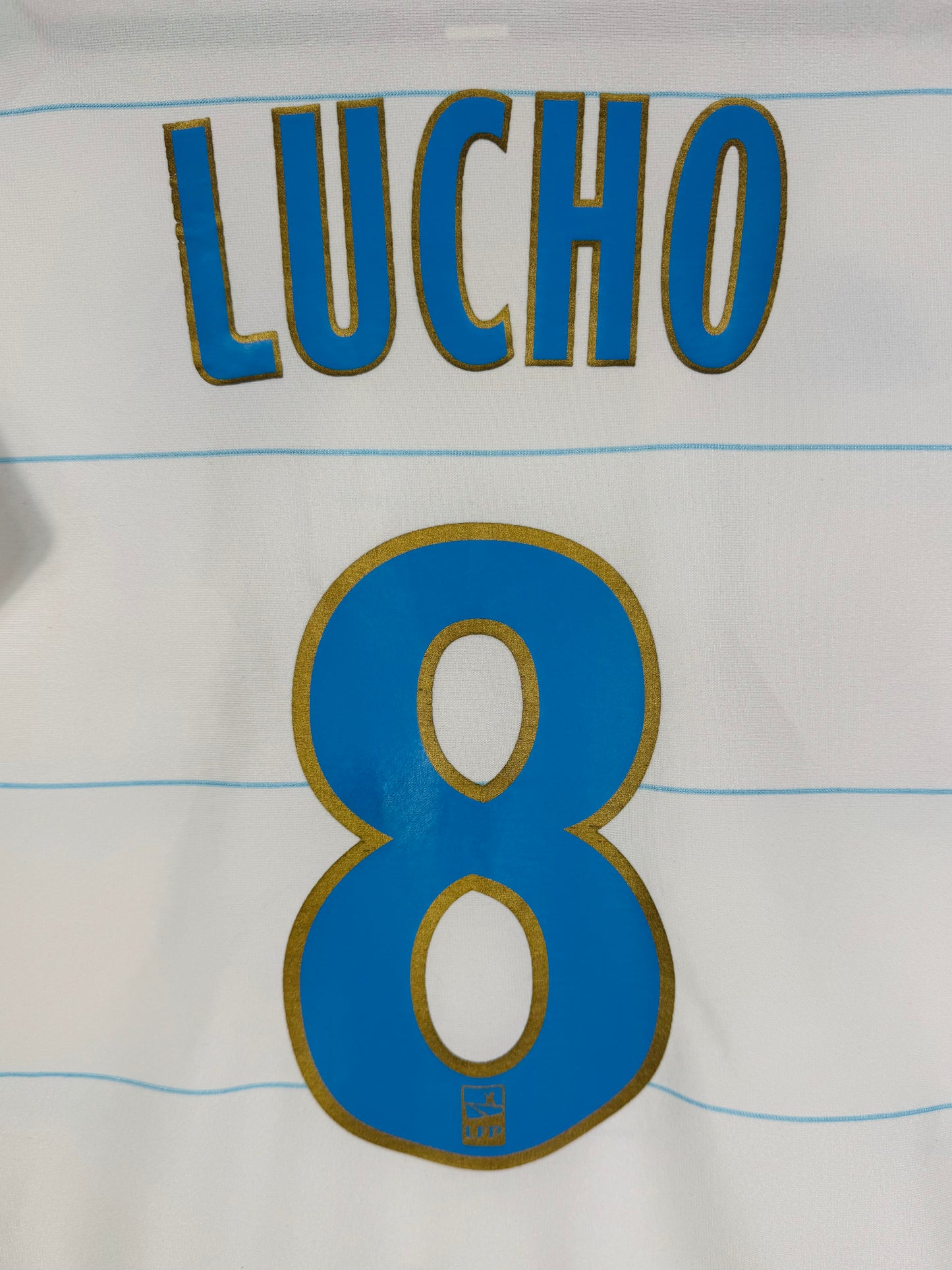 Zoom sur le nom LUCHO et le numéro 8 avec le logo du club intégré.