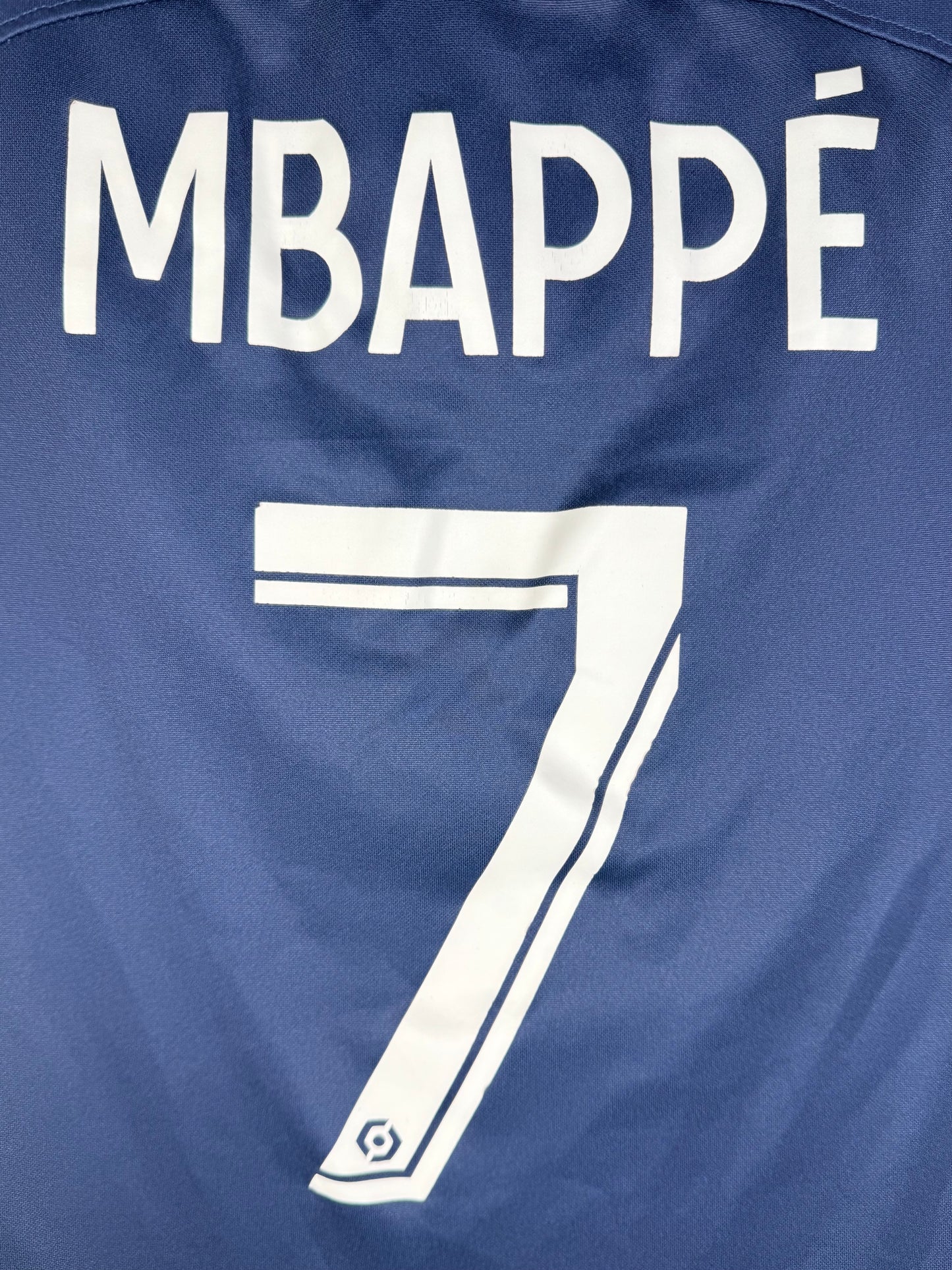 Gros plan numéro 7 Kylian Mbappé police officielle Ligue 1 maillot PSG 2023.