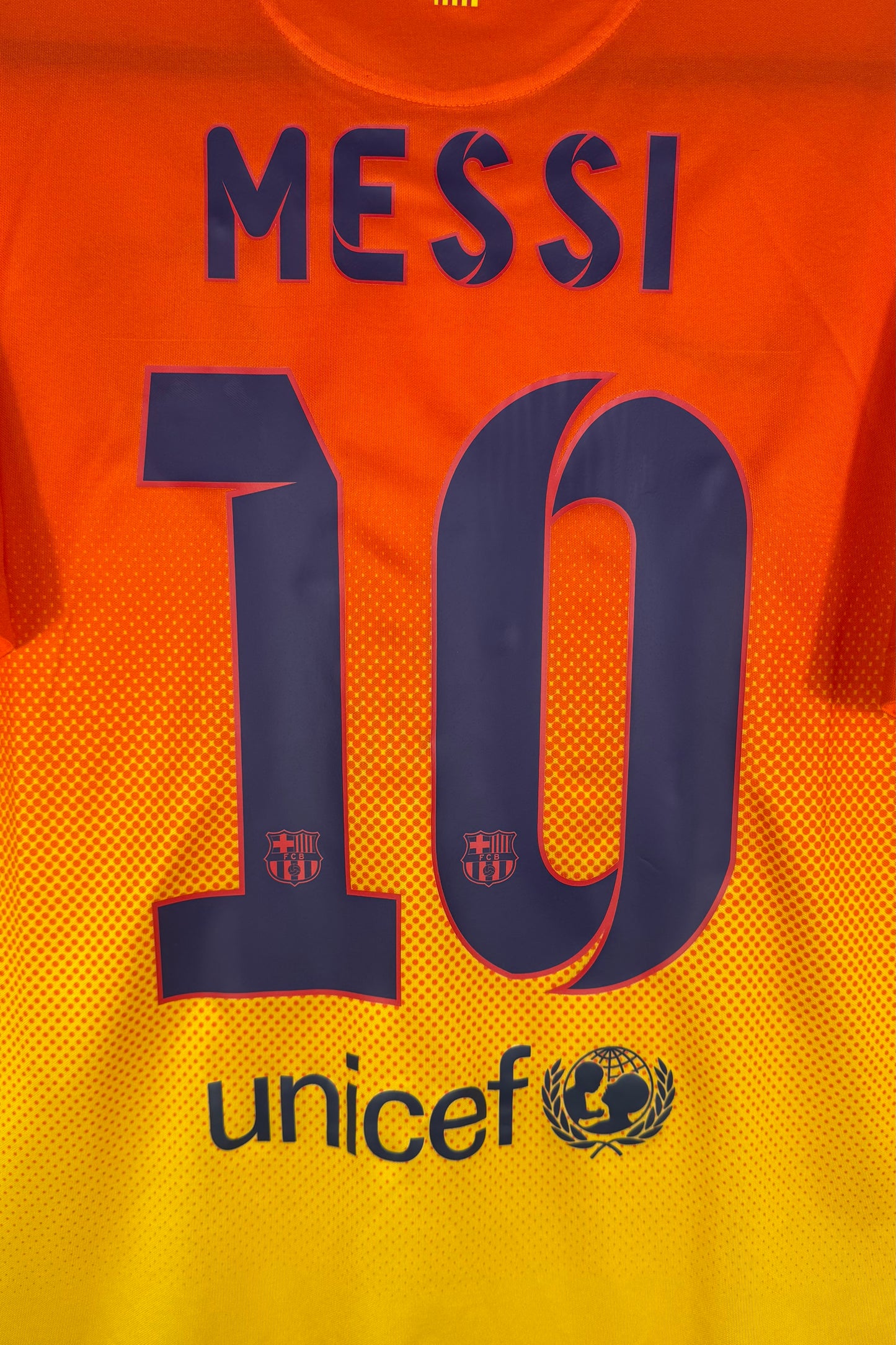Zoom sur le nom MESSI et le numéro 10 bleu marine avec logo Unicef.