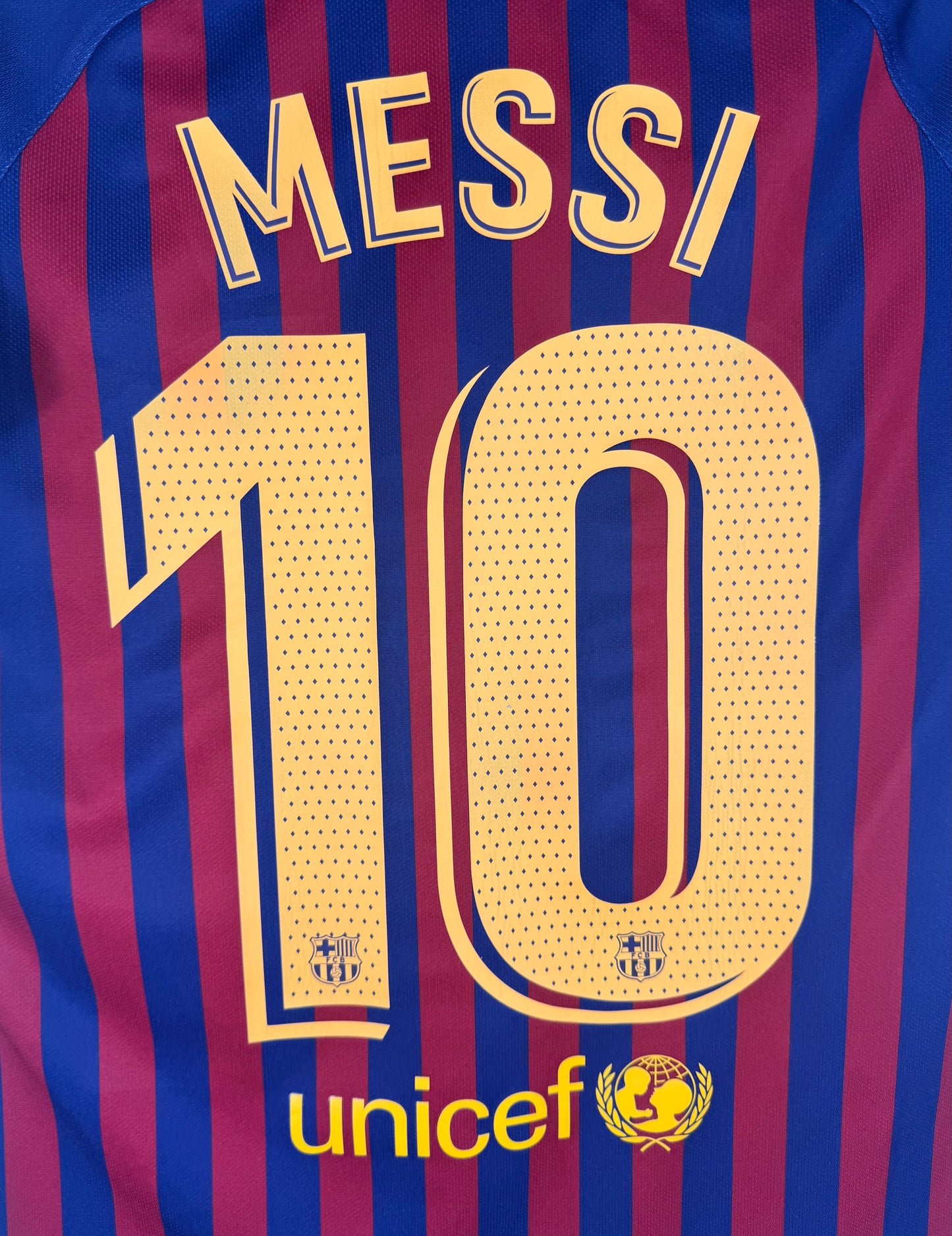Zoom sur le nom MESSI et le numéro 10 avec détail du logo Unicef en bas.
