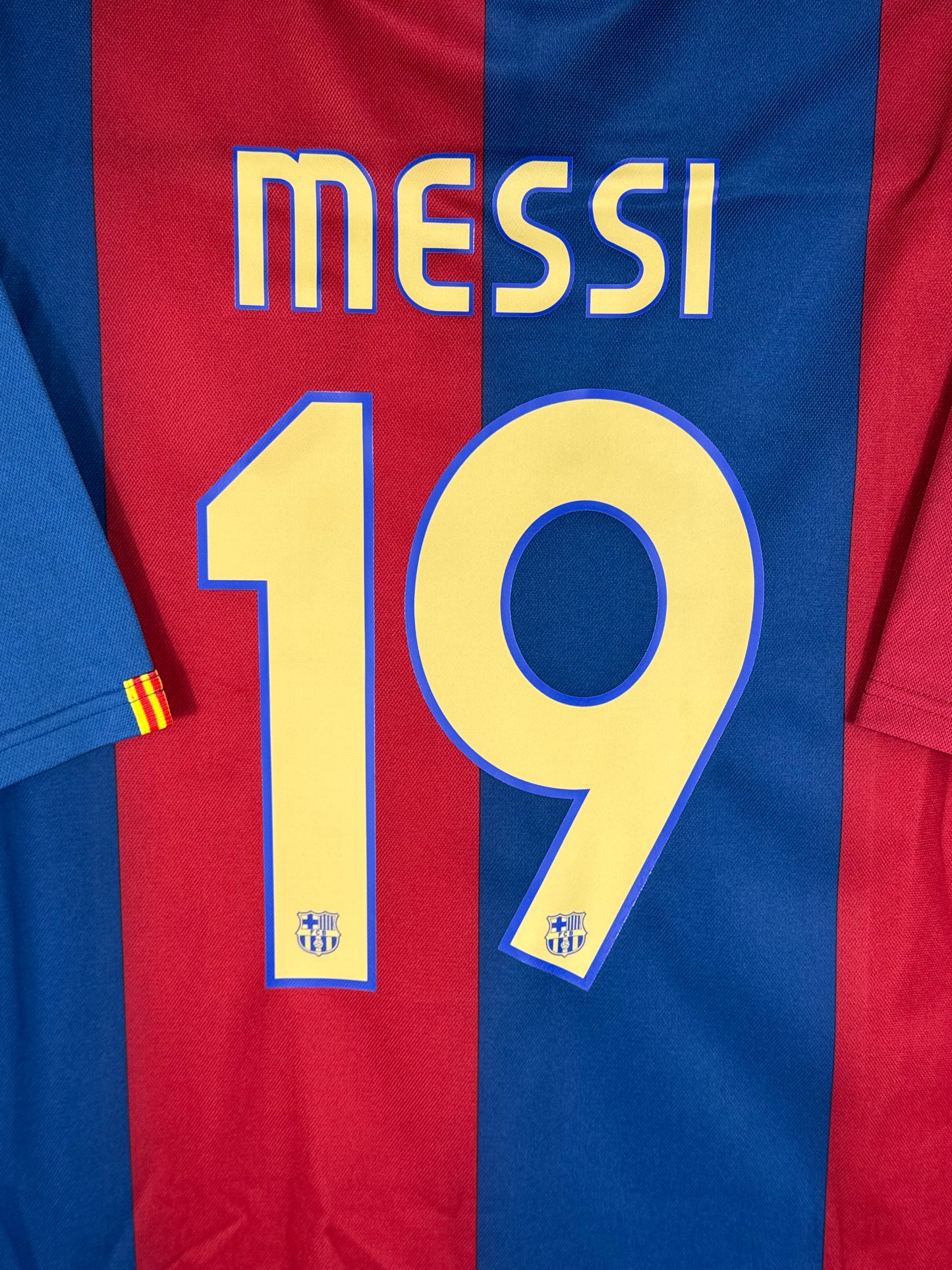 Zoom sur le nom MESSI et le numéro 19 jaune, typographie officielle du FC Barcelone 2007.