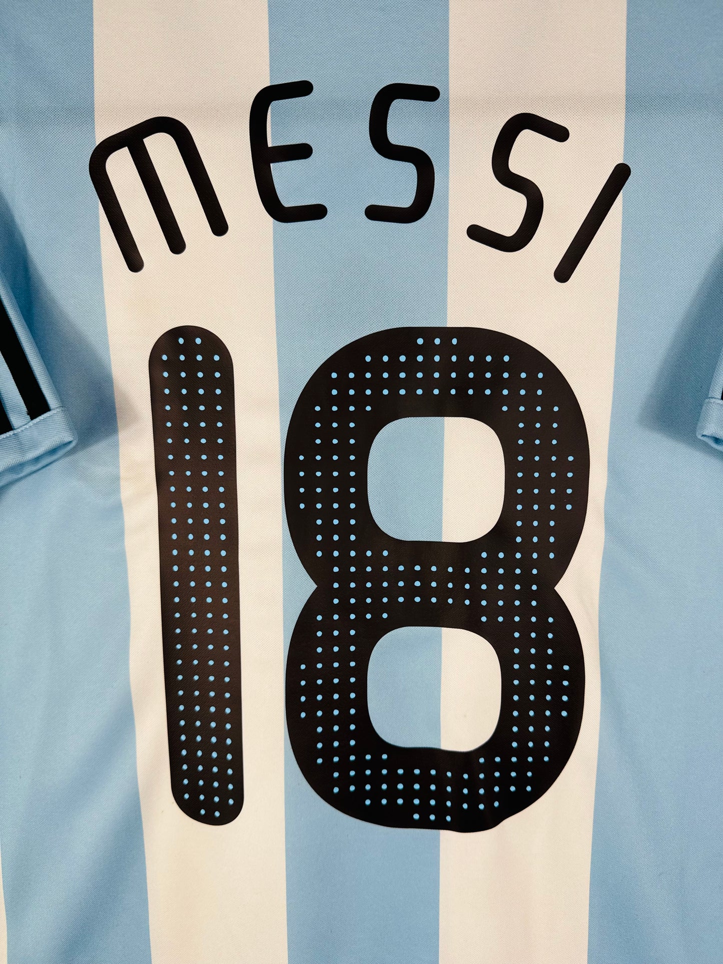 Zoom sur le nom MESSI en lettres noires, typographie officielle de l'époque.