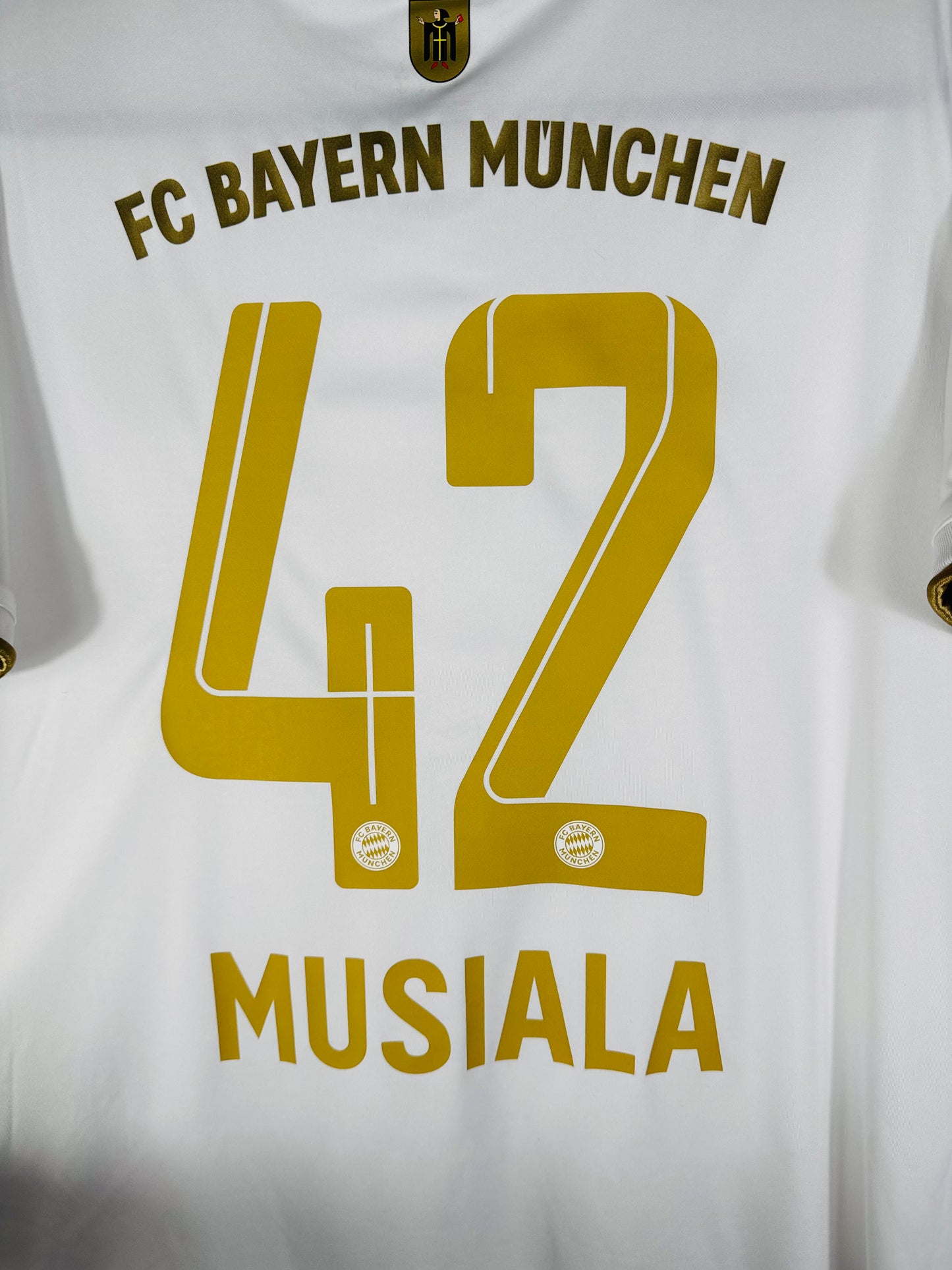 Zoom sur le nom MUSIALA et le numéro 42 en flocage doré officiel du Bayern Munich.