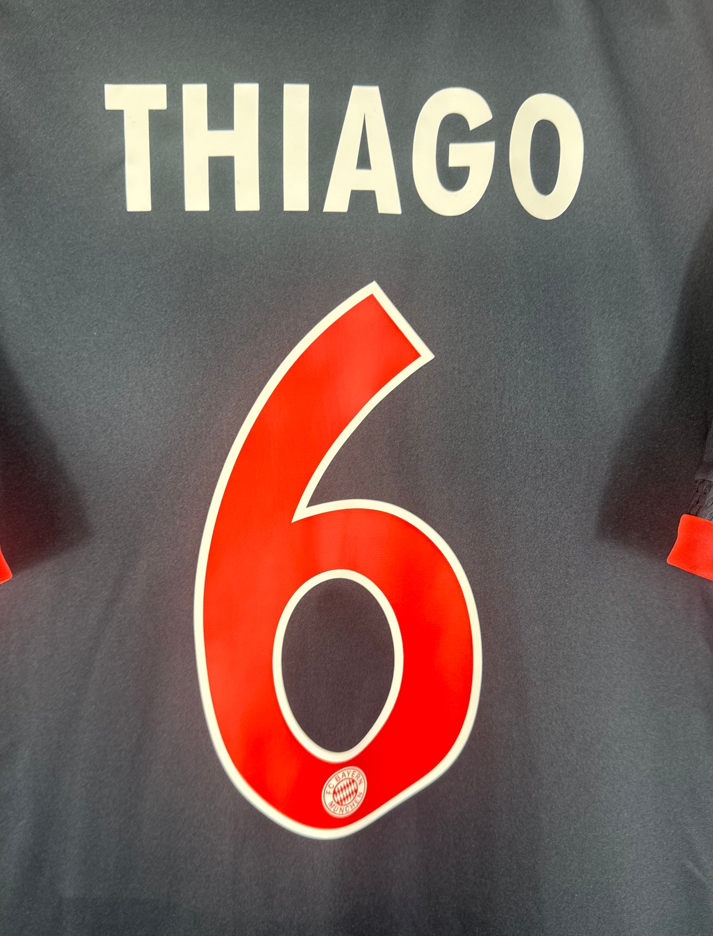 Zoom sur le numéro 6 rouge à bordure blanche et le nom THIAGO sur le maillot third.