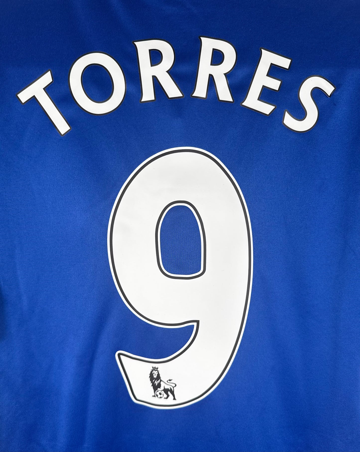 Zoom sur le nom TORRES et le numéro 9 avec le logo lion Premier League en bas.