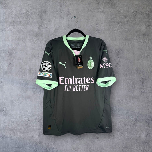 Vue de face du maillot AC Milan Third 2024/25 gris avec accents roses et verts.