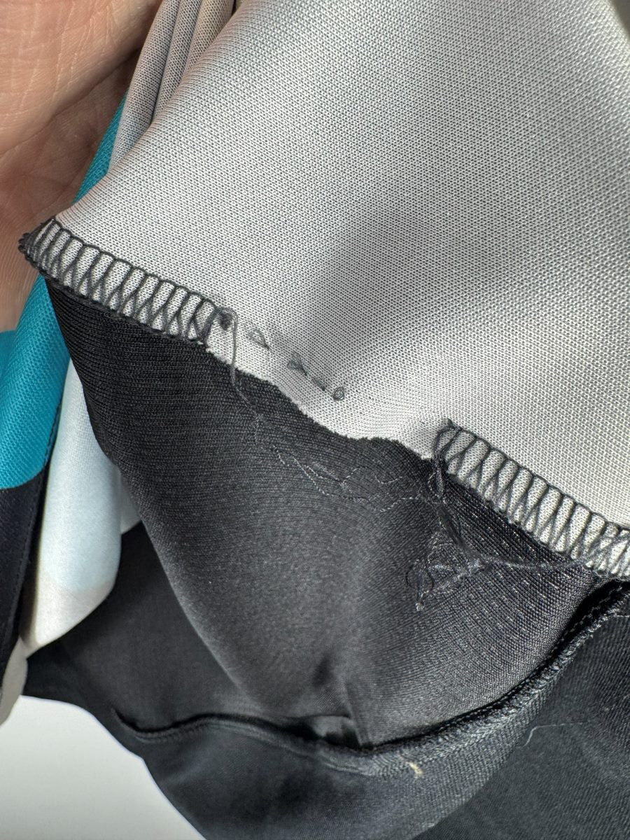 Étiquette intérieure arrachée du maillot Arsenal 2015-2016 third, photographiée en toute transparence