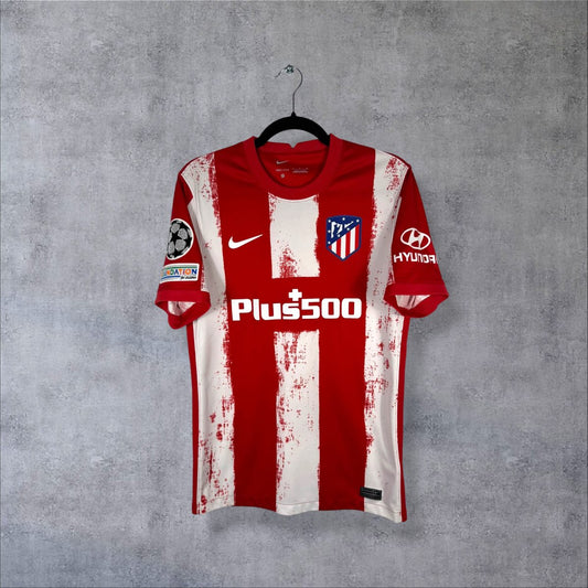 Maillot Atlético Madrid domicile 2021-2022 Nike de face, rayures rouges et blanches, sponsor Plus500