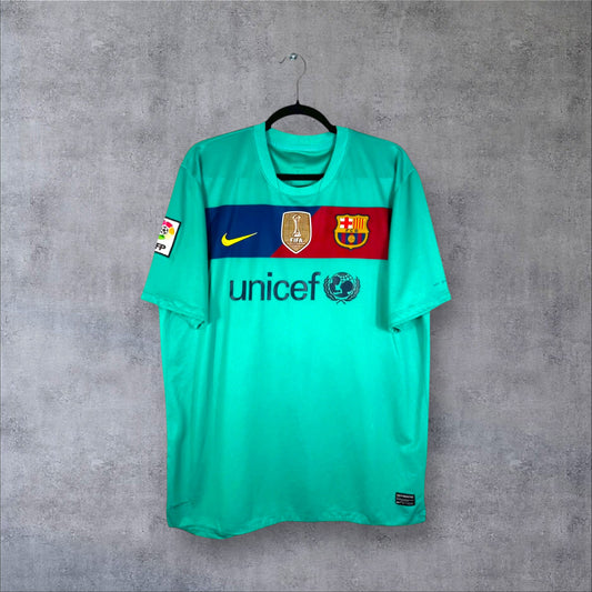 Vue de face du maillot FC Barcelone Extérieur 2010/11 vert avec bande blaugrana, sponsor Unicef et badge FIFA.