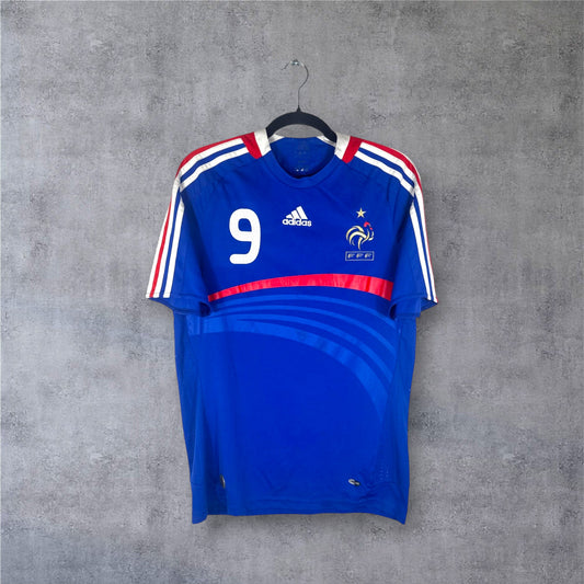 Vue de face du maillot France Euro 2008 bleu avec bande rouge et logo Adidas central.