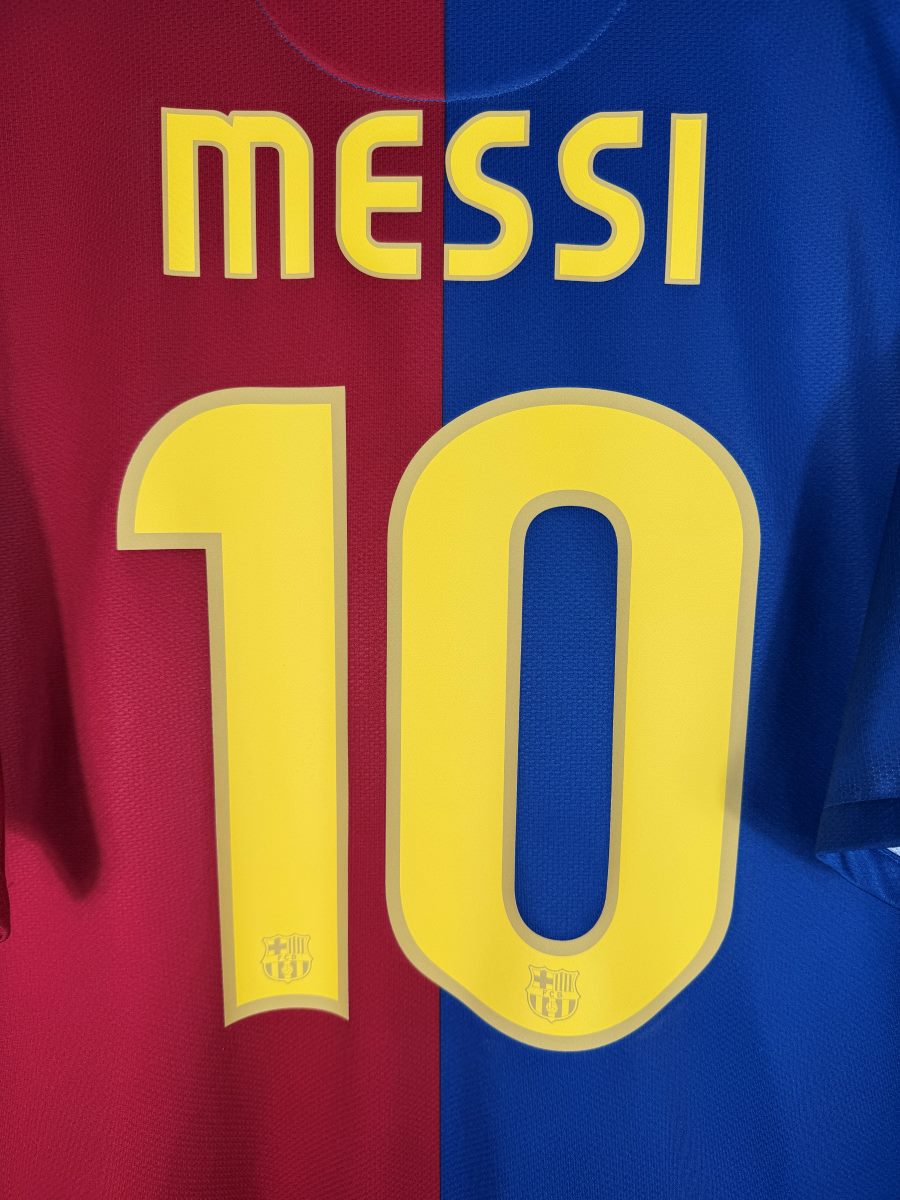 Détail du flocage Messi N°10 jaune bordé d'or avec écussons FCB, maillot Barcelone 2008-2009