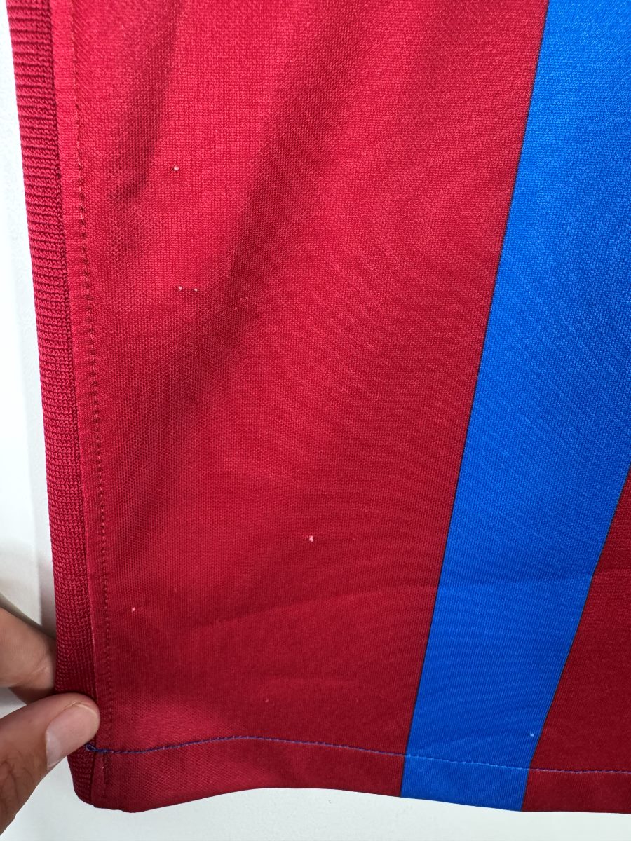 Défaut du maillot FC Barcelone 2021-2022 : micro-points blancs isolés sur la bande grenat du bas du maillot