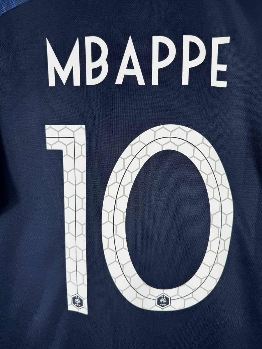 Gros plan du flocage Mbappé N°10 motif nid d'abeille sur le maillot France 2018