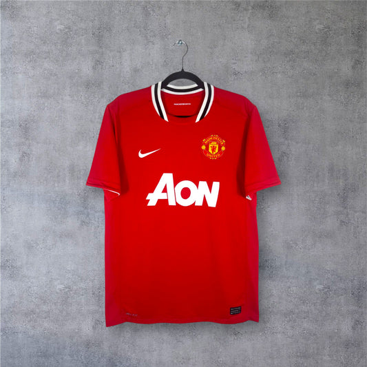 Vue de face du maillot rouge Manchester United 2011/12 avec son col noir et blanc iconique.