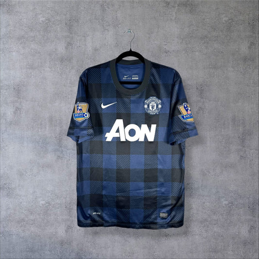 Face du maillot Manchester United 2013-2014 extérieur Nike à motif tartan noir et bleu marine avec sponsor AON et écusson des Red Devils