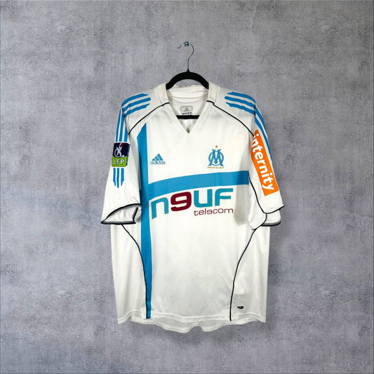 Maillot OM domicile 2005-2006 adidas de face, sponsor Neuf Telecom, croix bleu ciel et manche Internity
