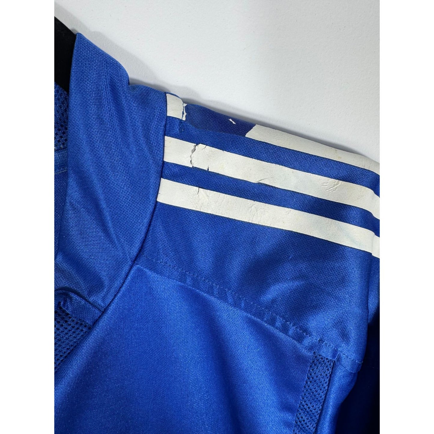 Gros plan sur la légère usure des bandes Adidas sur les épaules du maillot du Real Madrid