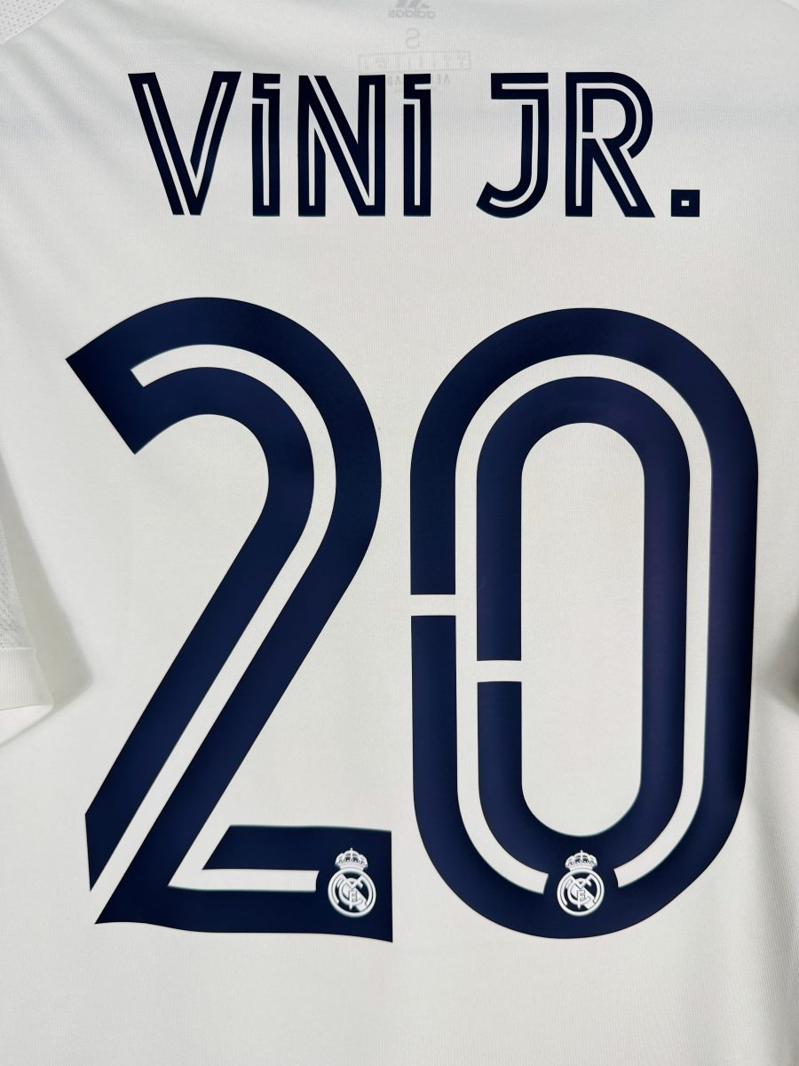 Détail du flocage VINI JR. N°20 en police Ligue des Champions sur le maillot Real Madrid 2020-2021