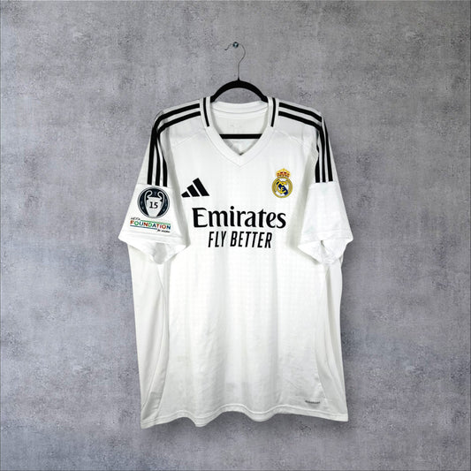 Vue de face du maillot Real Madrid 2024-2025 domicile blanc avec sponsor Emirates et col en V.