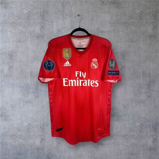 Vue de face du maillot Real Madrid Third 2019 rouge corail version joueur avec badge FIFA or.
