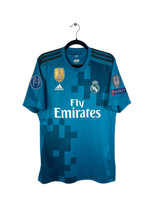 Vue de face du maillot Real Madrid Third 2017/18 couleur sarcelle avec motifs pixelisés.