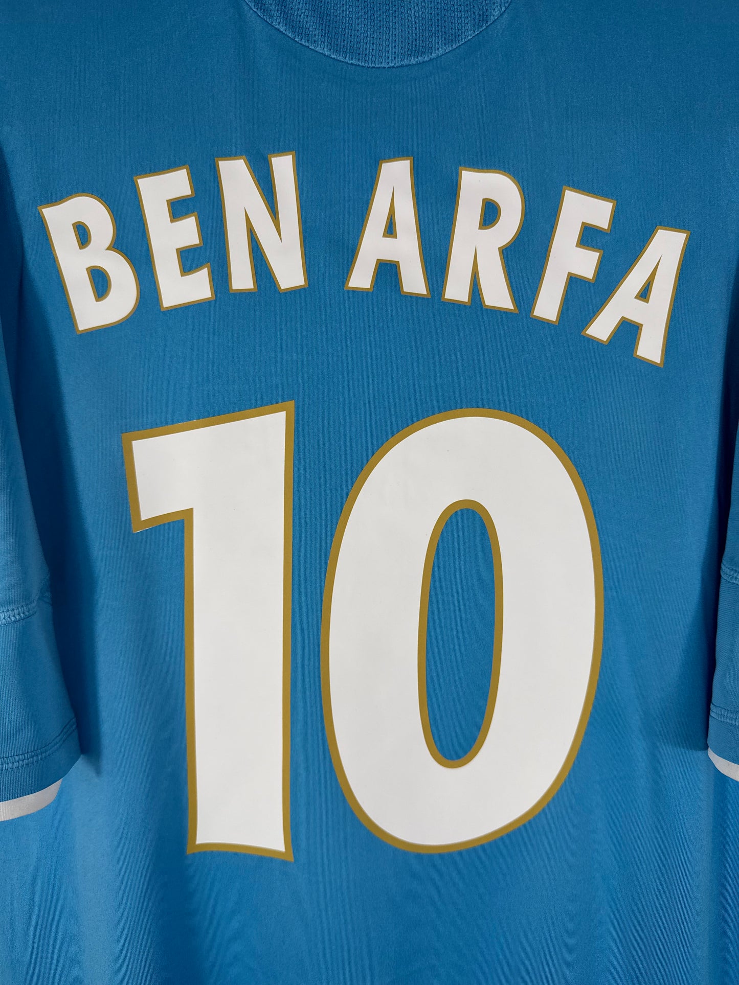 Détail du nom BEN ARFA et du numéro 10 blanc avec liseré or, typographie européenne OM 2011.