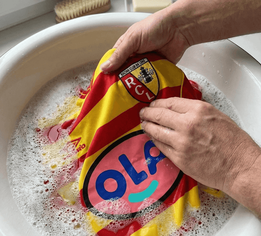 Lavage à la main délicat d'un maillot vintage RC Lens dans une bassine