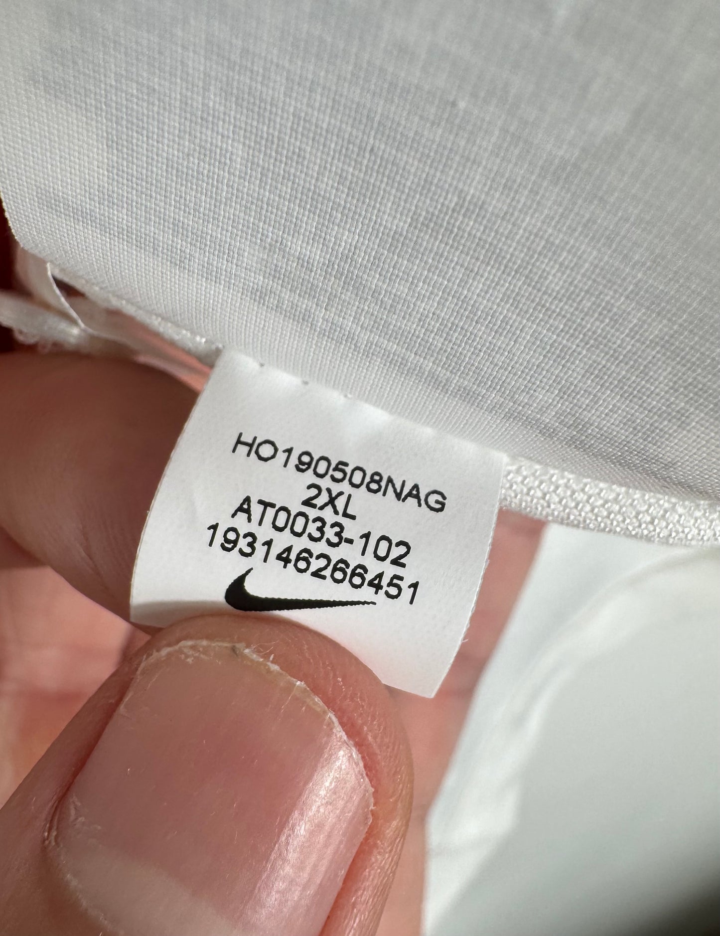 Étiquette interne Nike code AT0033-102 et taille XXL certifiant l'authenticité.