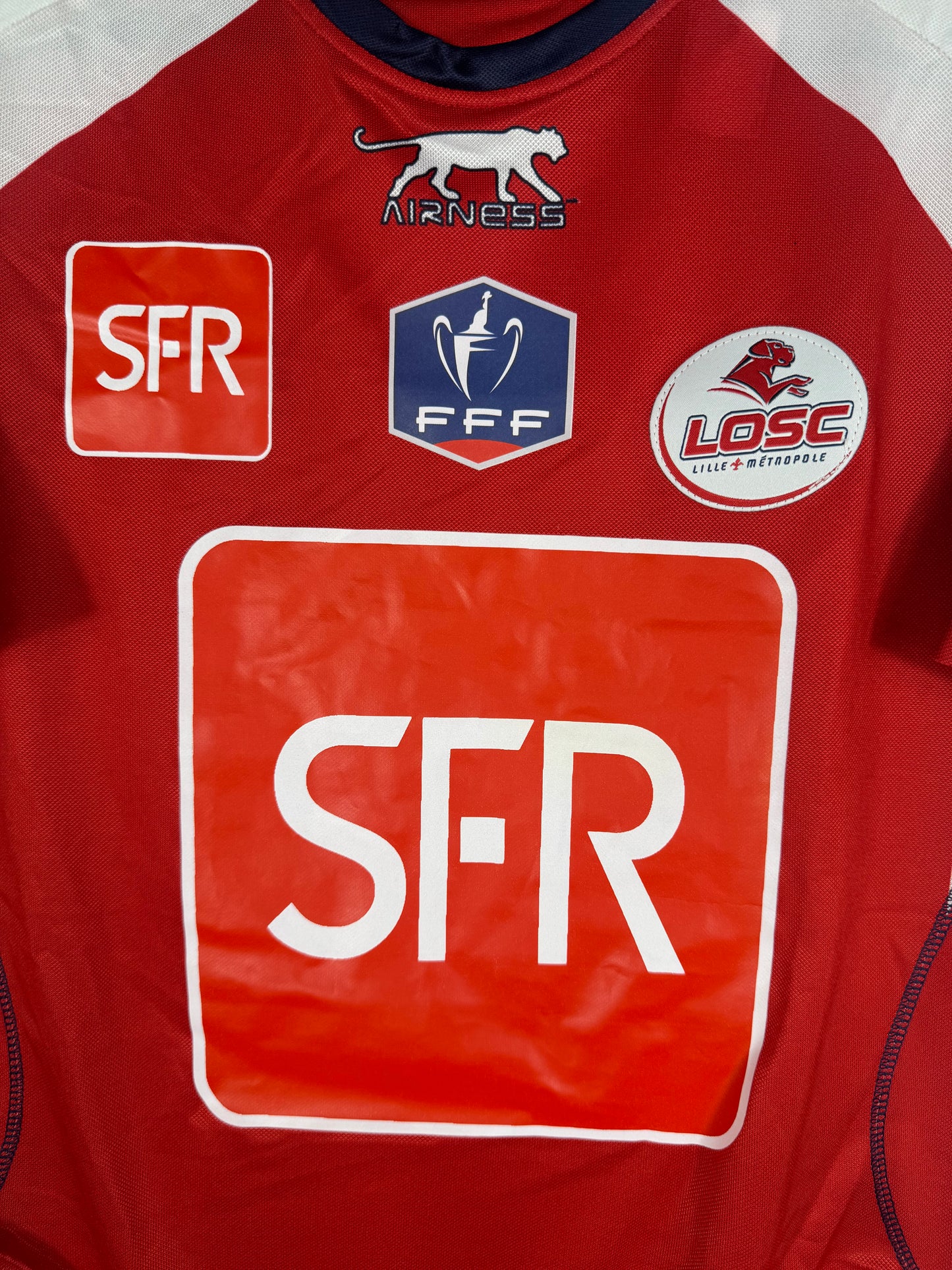 Gros plan sur le badge FFF Coupe de France, le logo LOSC et le sponsor SFR.