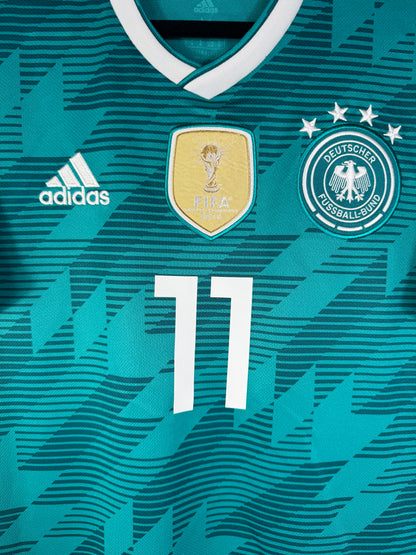 Gros plan sur le badge FIFA World Champions 2014 doré, l'écusson de l'Allemagne aux 4 étoiles et le logo Adidas blanc.