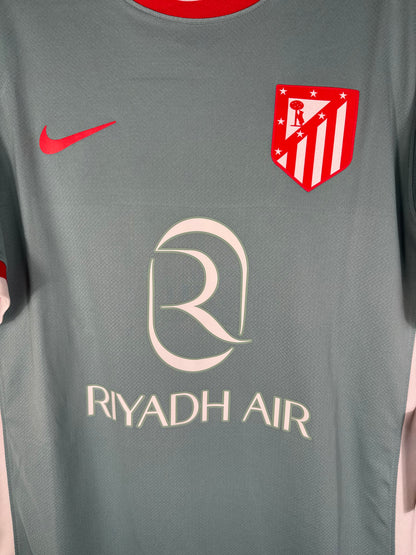 Gros plan sur l'écusson historique de l'Atletico Madrid brodé, symbole du retour aux sources en 2025.