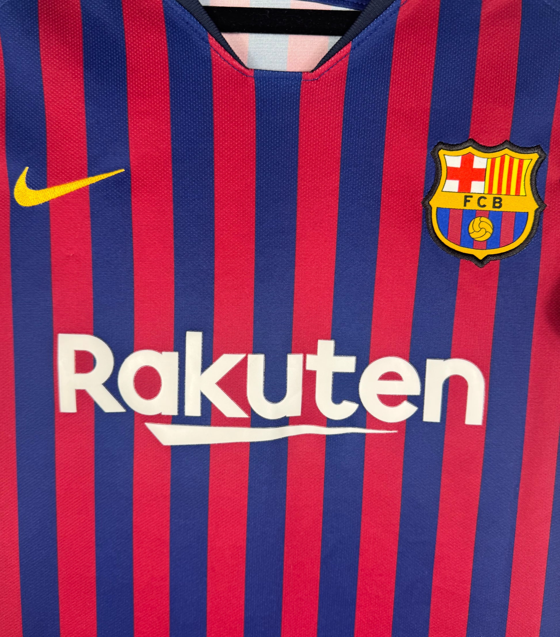 Gros plan sur l'écusson FCB et le logo Nike jaune sur le modèle femme.