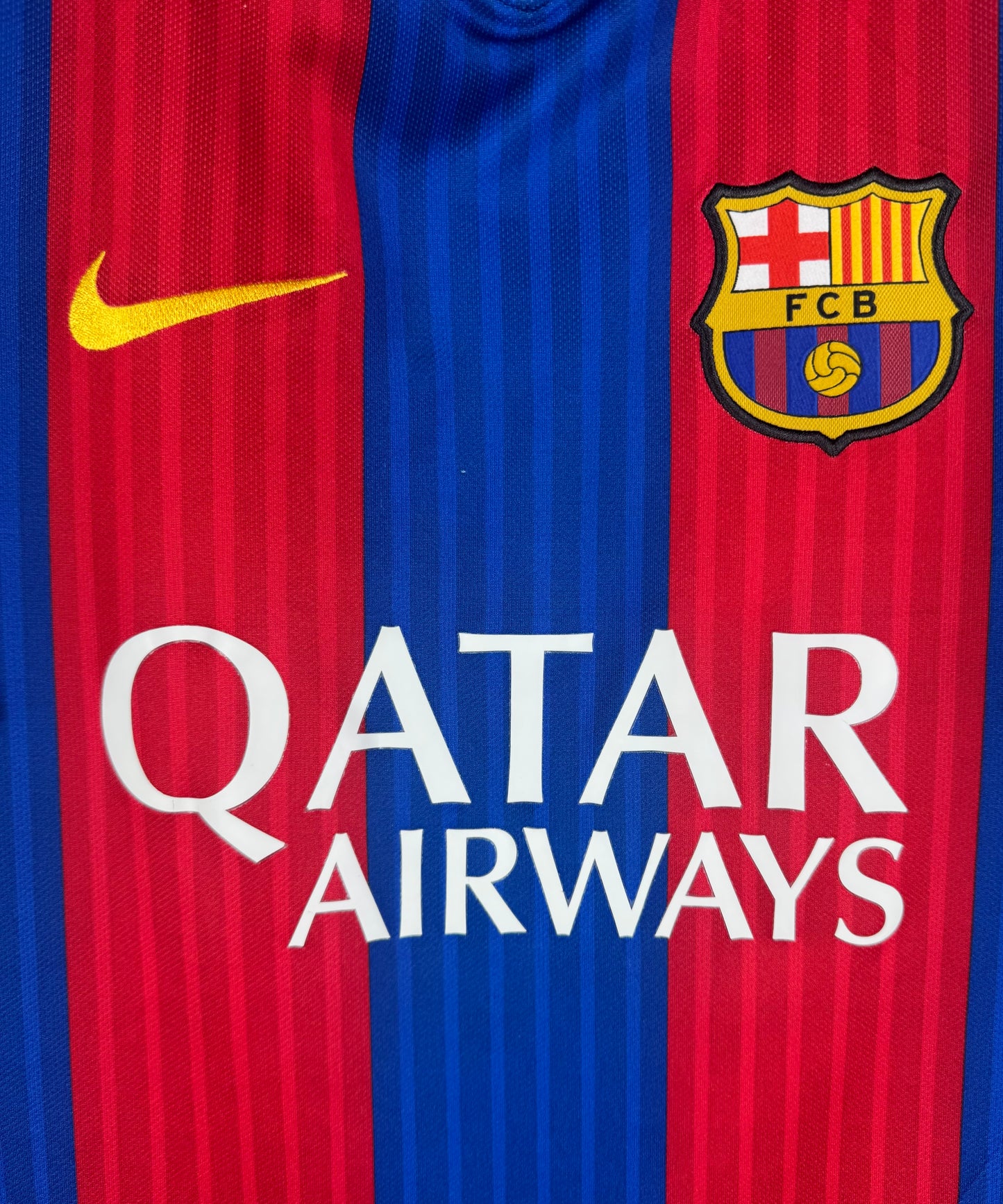 Gros plan sur l'écusson FC Barcelone et le sponsor Qatar Airways blanc.