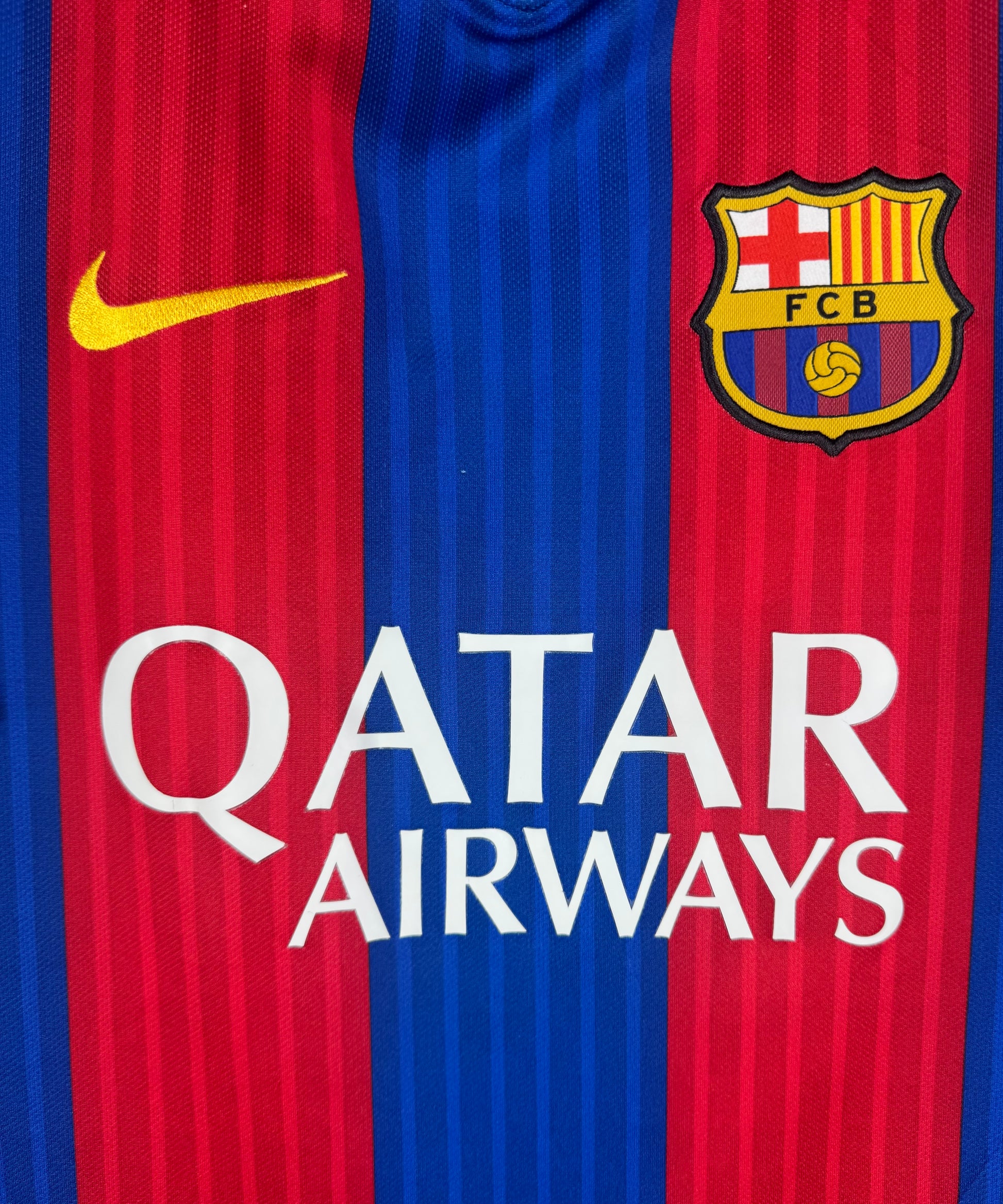 Gros plan sur l'écusson FC Barcelone et le sponsor Qatar Airways blanc.