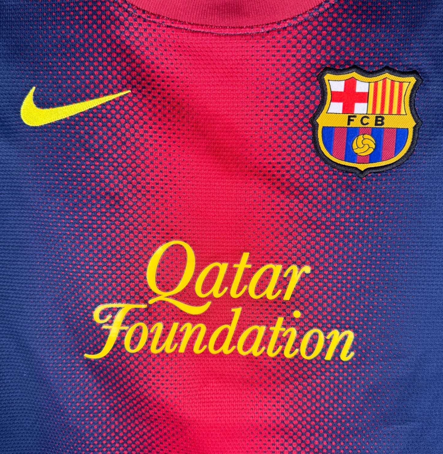 Gros plan sur l'écusson du Barça et le sponsor Qatar Foundation jaune.