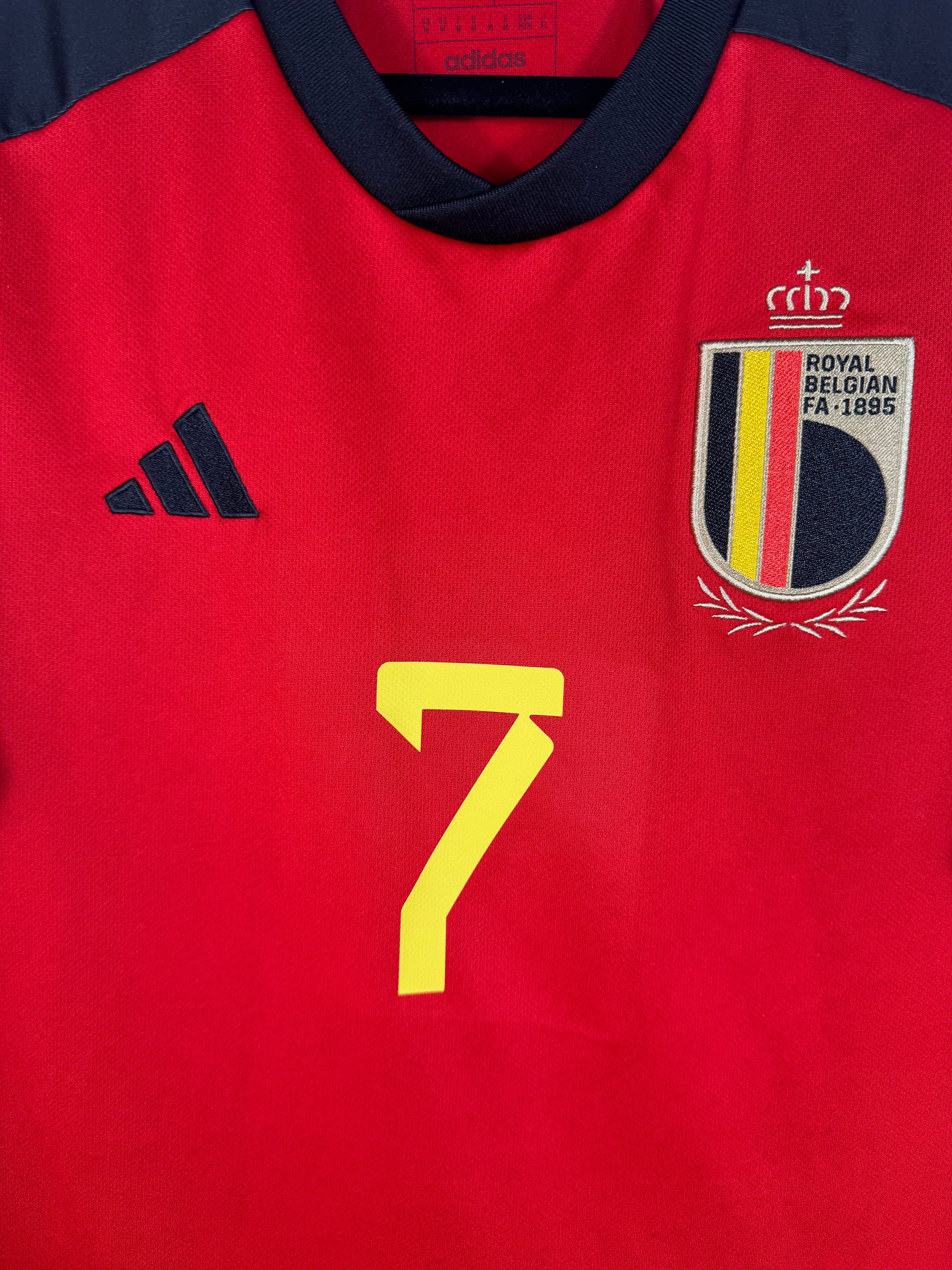 Gros plan sur le logo de la Fédération Belge de Football (RBFA) et le logo Adidas noir.
