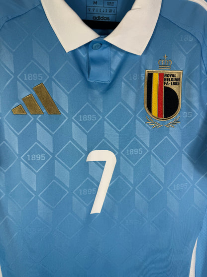 Gros plan sur l'écusson de la sélection belge et le logo Adidas doré sur le maillot avec le numéro 7 au centre.