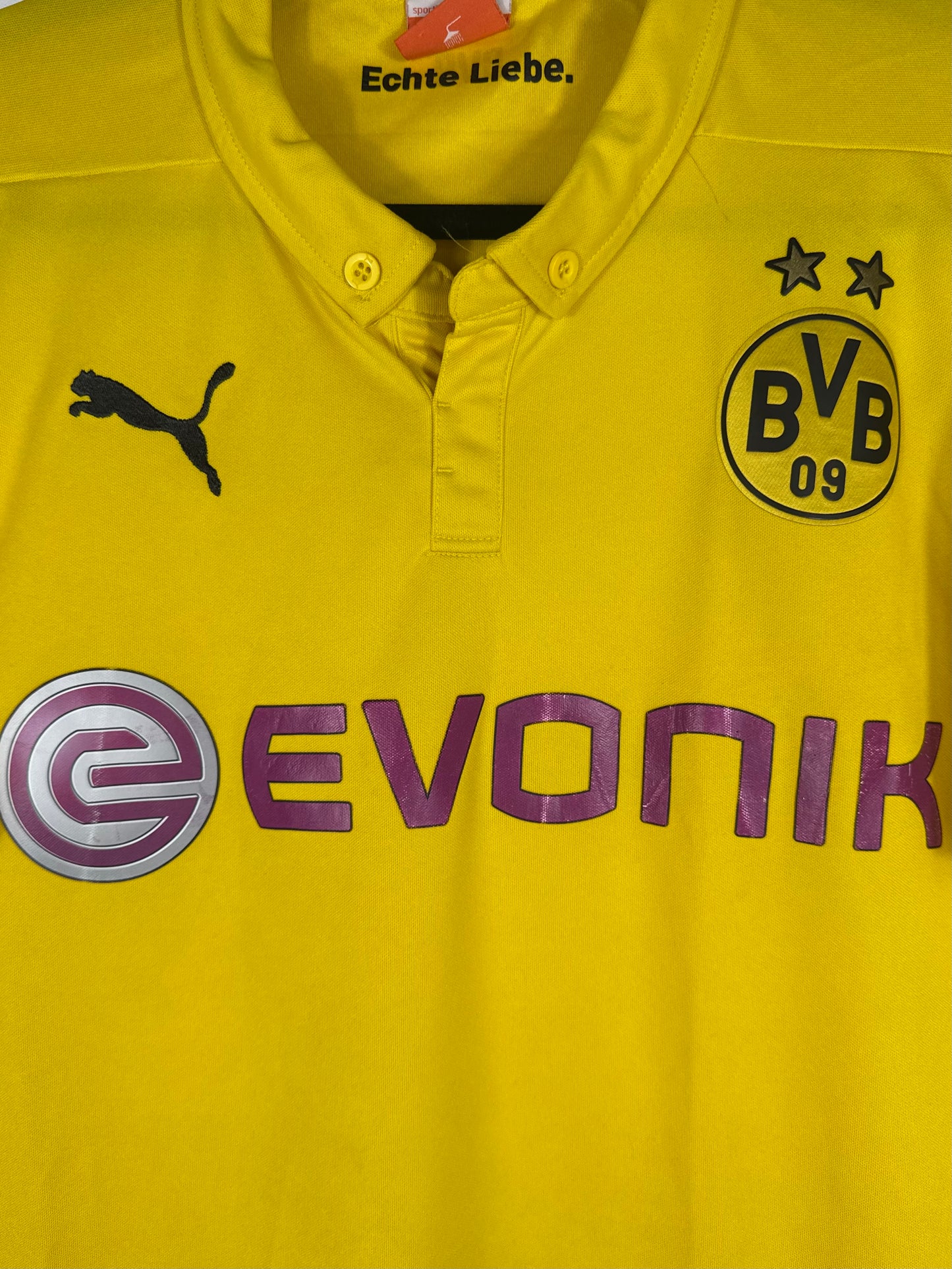 Gros plan sur l'écusson BVB 09, le logo Puma et le sponsor Evonik violet.