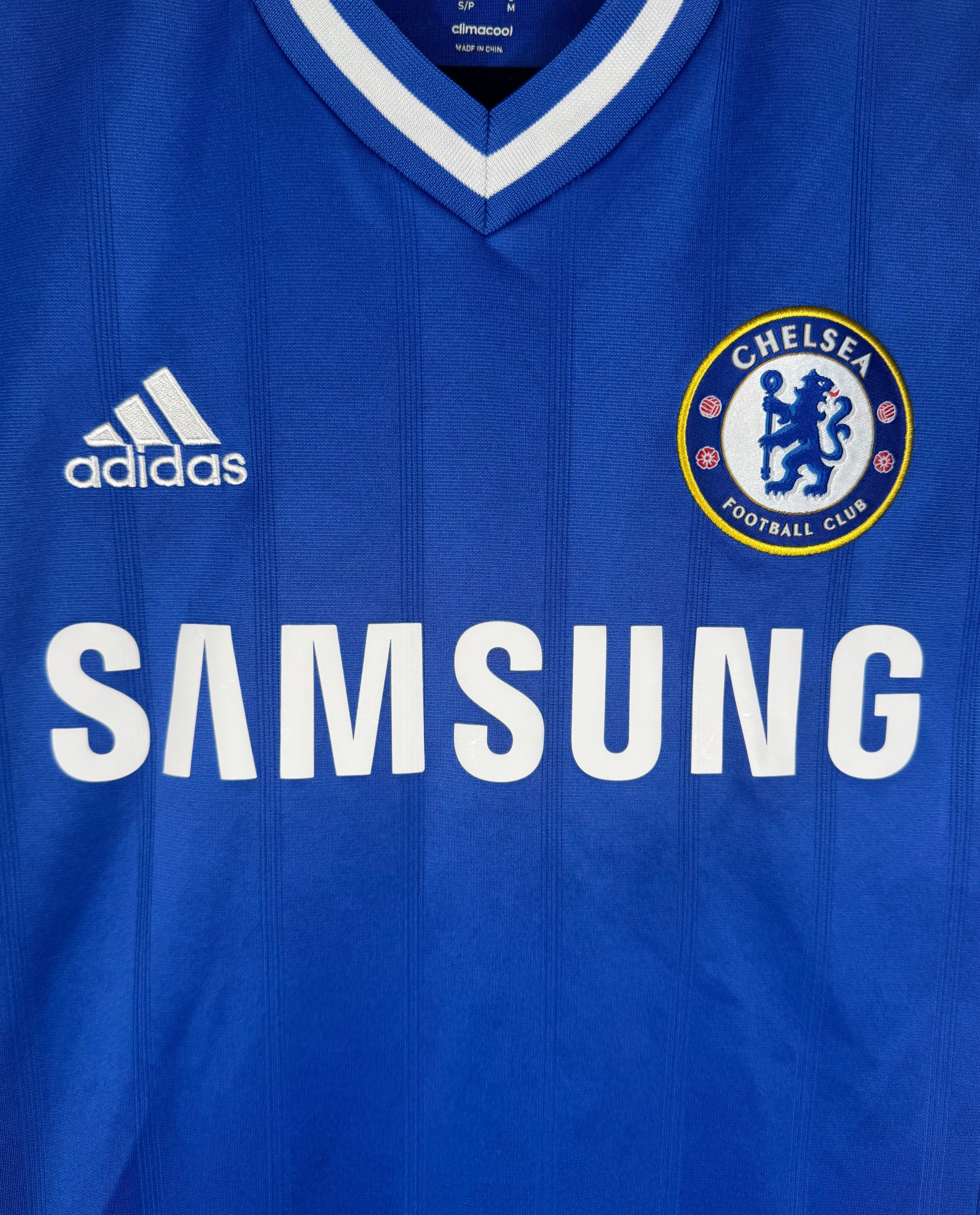 Gros plan sur l'écusson brodé du Chelsea FC et le sponsor Samsung emblématique.