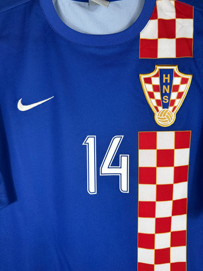 Gros plan sur l'écusson de la fédération croate, le logo Nike et le numéro 14 sur la bande à damier.
