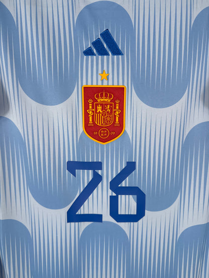 Gros plan sur l'écusson de la sélection espagnole et le logo Adidas bleu marine centrés sur le torse.