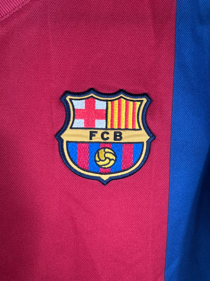 Gros plan sur l'écusson historique du FC Barcelone brodé sur le tissu domicile.