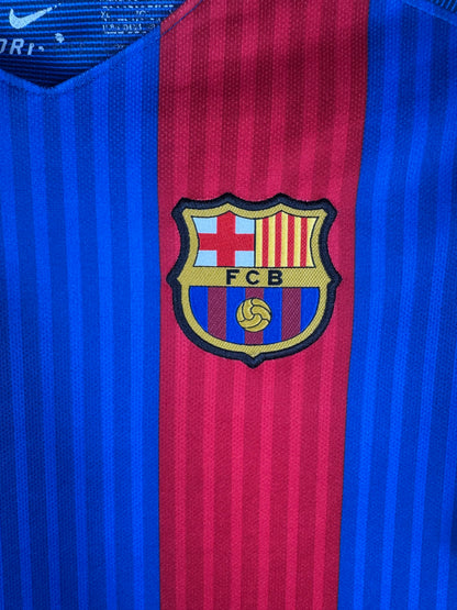 Gros plan sur l'écusson du FC Barcelone brodé et le logo Nike doré sur le torse.