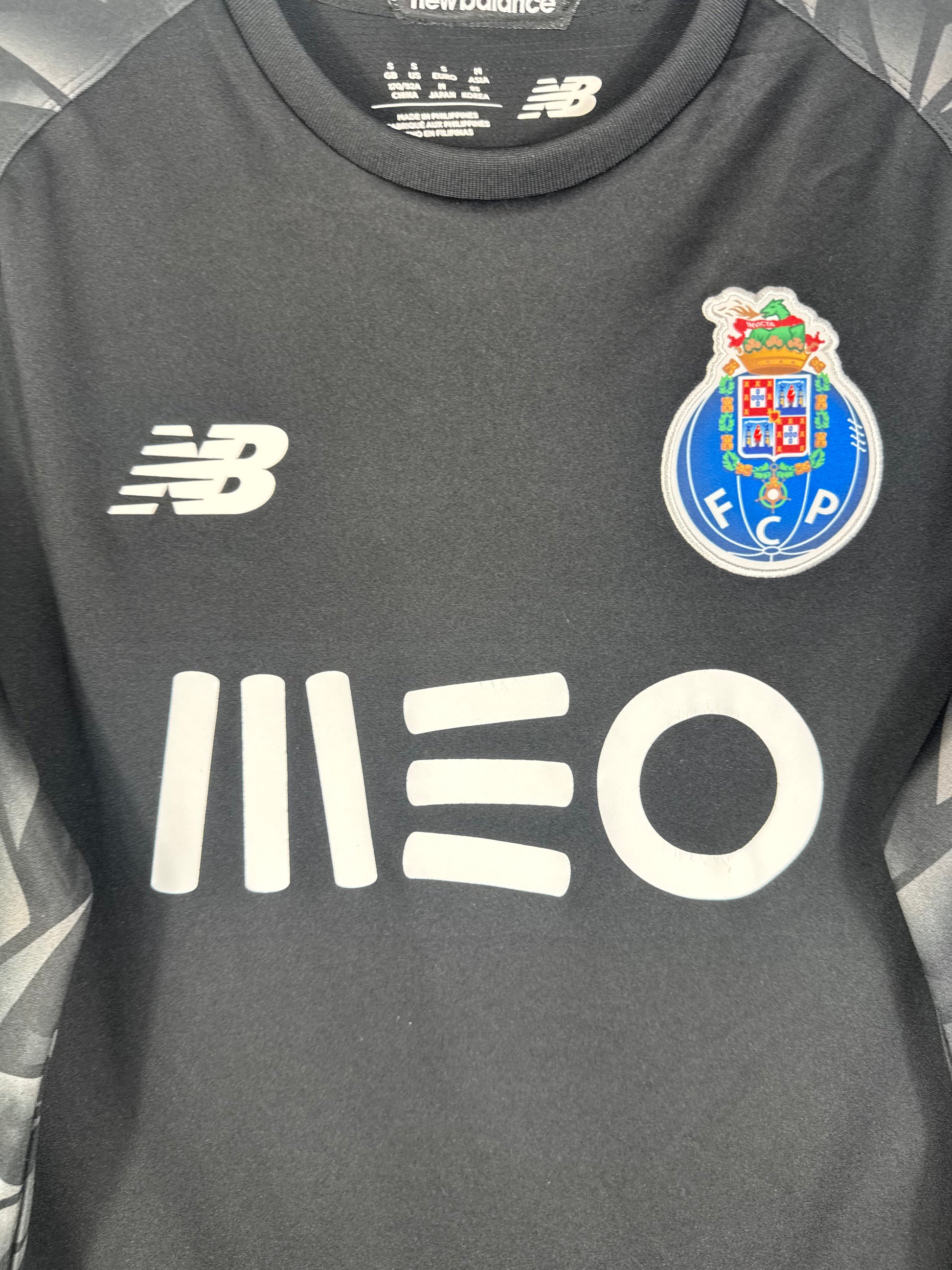 Gros plan sur l'écusson du FC Porto et le logo New Balance blanc sur le torse.